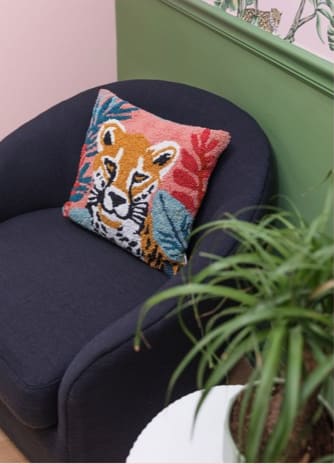 A cozy chair and colorful tiger cushion in the lounge